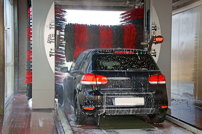 Ein Auto in einer Waschanlage, die weiches Wasser durch Enthärtungsanlagen erhält.